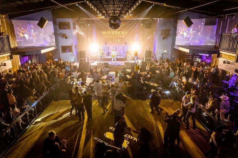 Crowd enjoying live music and dancing at Mavericks, a lively indoor concert and dance venue.